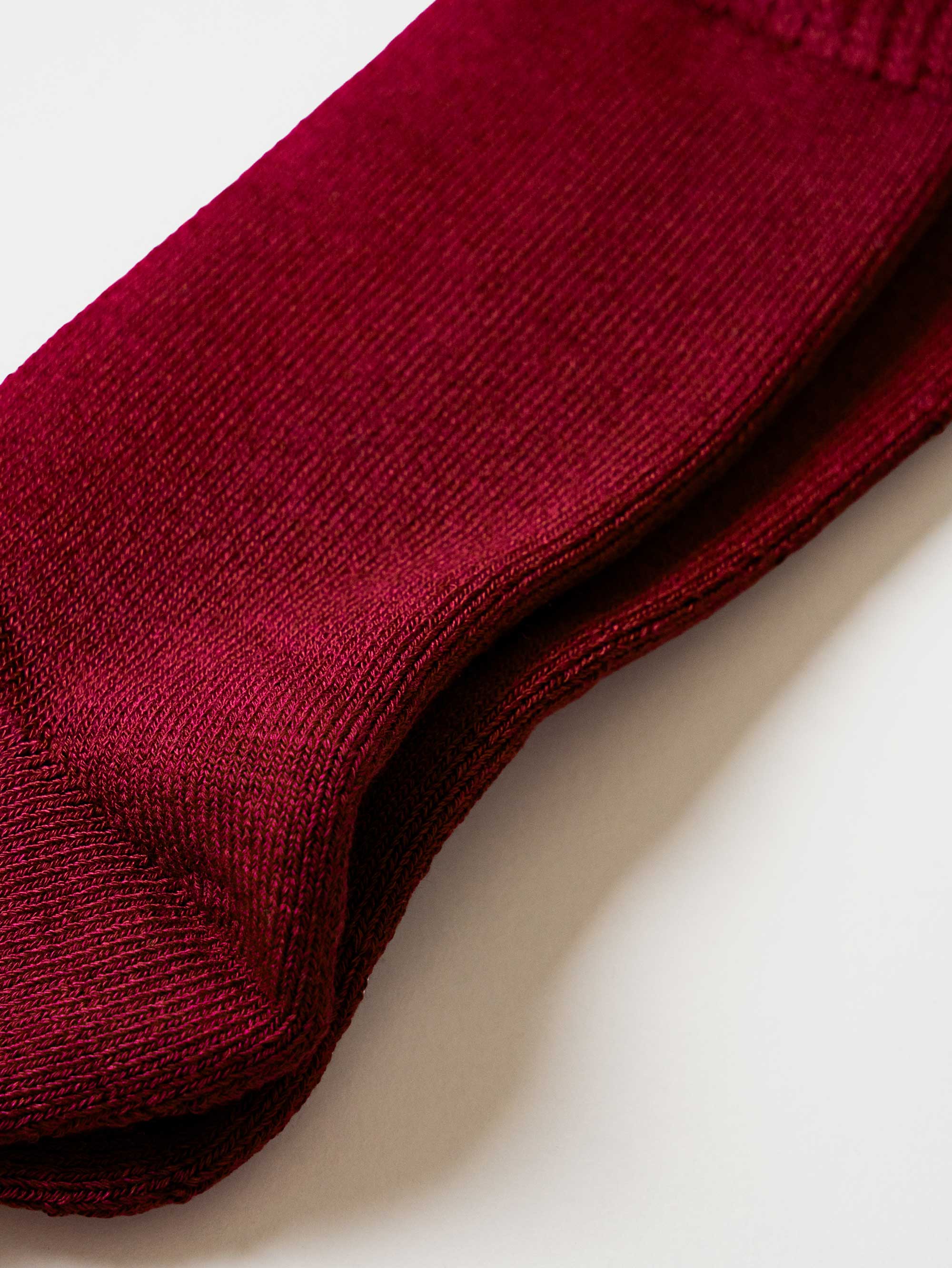 Closeup of maroon bamboo work sock on a white background