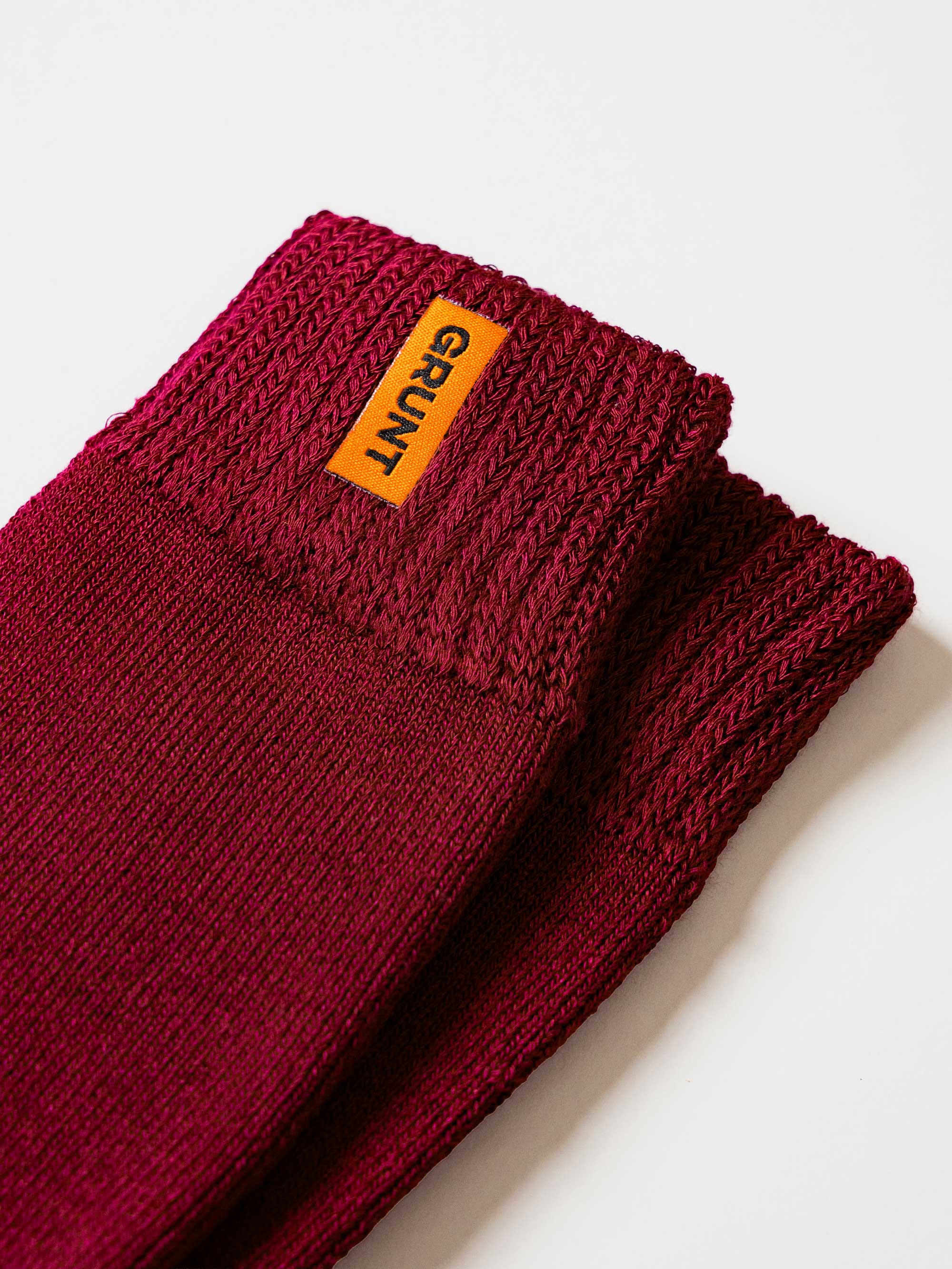 Maroon bamboo work sock with a Grunt brand label on a white background