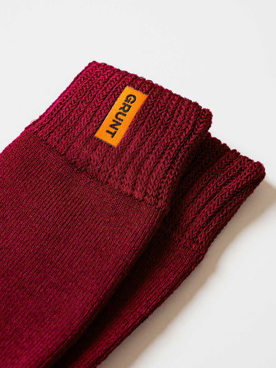 Maroon bamboo work sock with a Grunt brand label on a white background