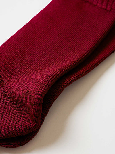 Closeup of maroon bamboo work sock on a white background